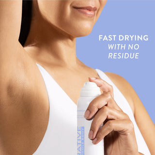 Woman spraying Native Cotton & Lily Whole Body Deodorant under arm, wearing a white tank top