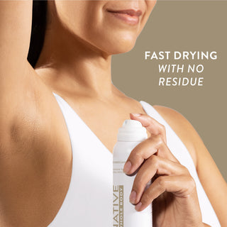 Woman spraying Native Sandalwood & Shea Butter Whole Body Deodorant under arm, wearing a white tank top