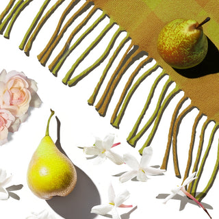 Two pears arranged with jasmine flowers, light roses, and a green scarf