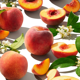 Arrangement of whole peaches and halved peaches, styled with jasmine flowers