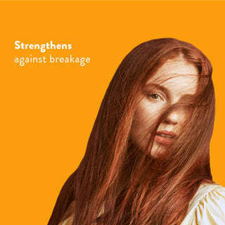Woman with long red hair with text reading “Locks in moisture and helps strengthen against breakage”
